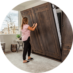 woman opening murphy bed with murphy bed mechanism.