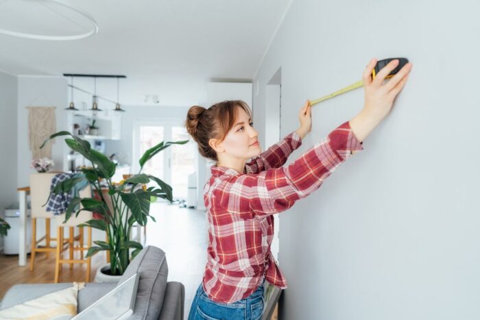 Woman measuring her wall